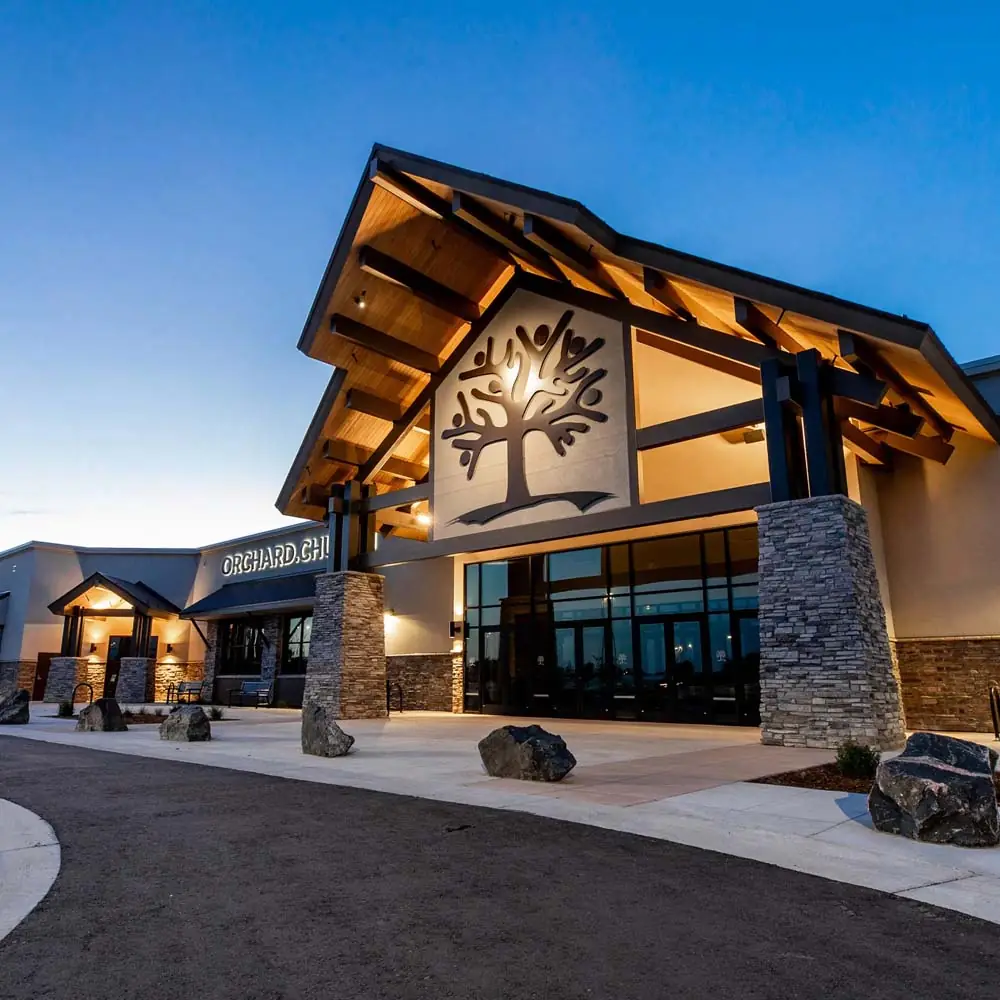 Church entrance with a timber canopy lit at dusk
